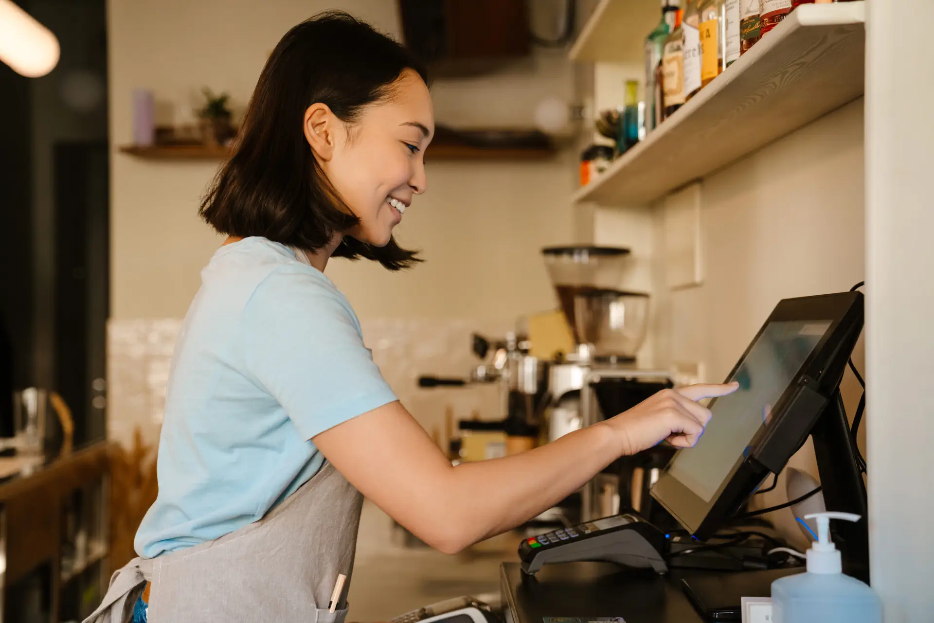 Small business owner using a point-of-sale system at the counter