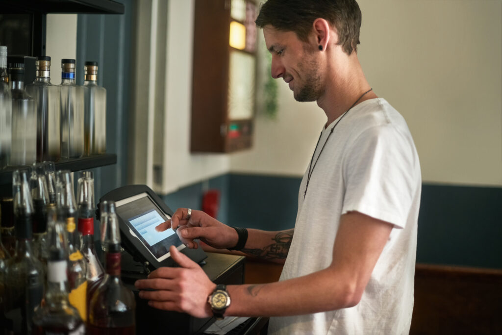Restaurant employee operating a point of sale system behind the counter