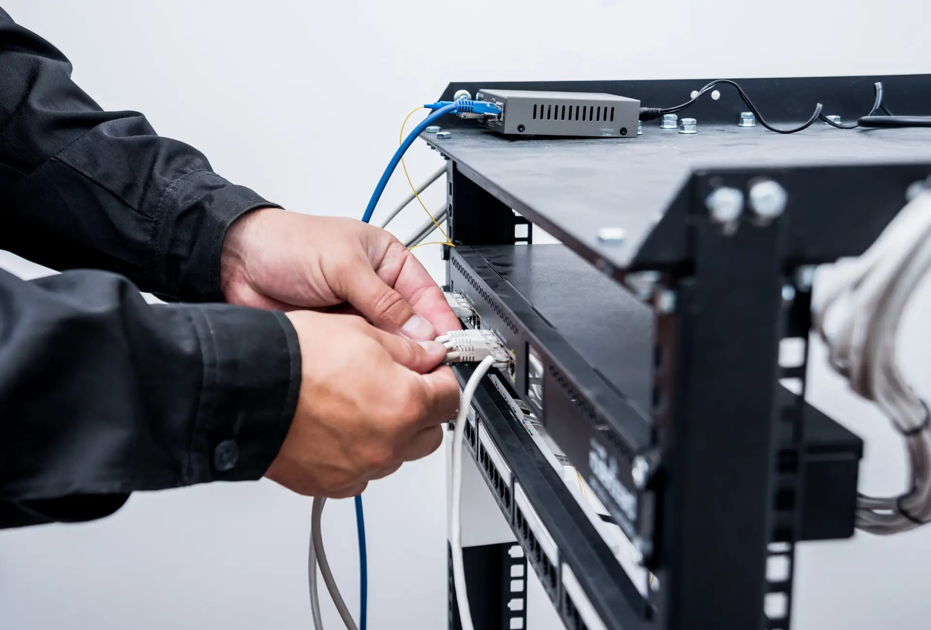 Technician installing and connecting network equipment to support business technology systems